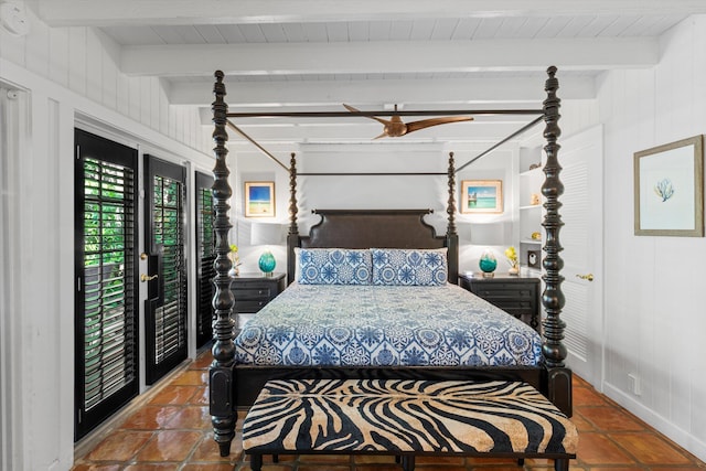 bedroom featuring beamed ceiling, tile patterned flooring, and access to exterior