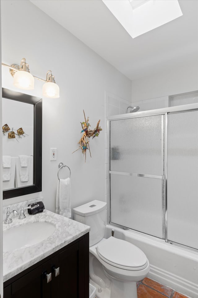 full bathroom featuring enclosed tub / shower combo, a skylight, vanity, tile patterned floors, and toilet