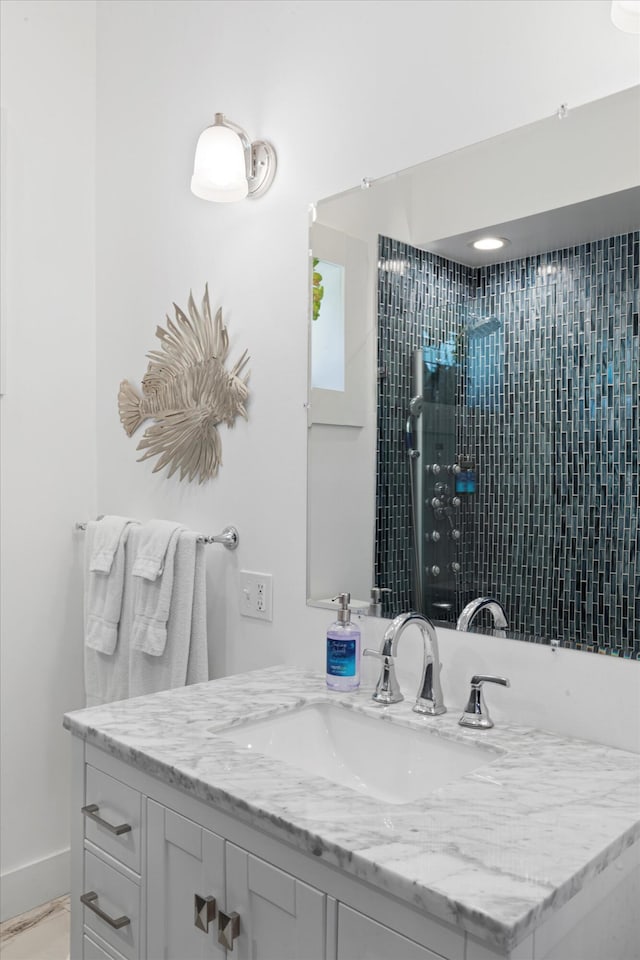 bathroom with vanity and a tile shower