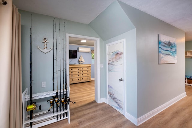 corridor with hardwood / wood-style flooring and a wall unit AC