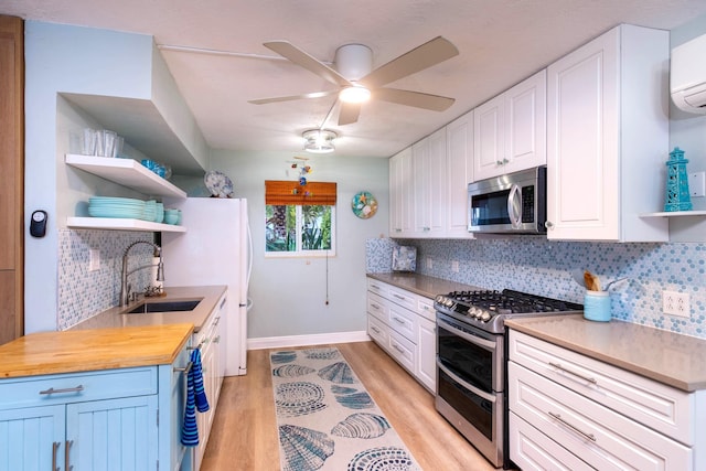 kitchen with white cabinetry, butcher block counters, and appliances with stainless steel finishes