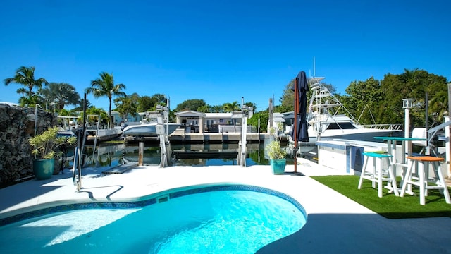 view of swimming pool with a water view and a dock