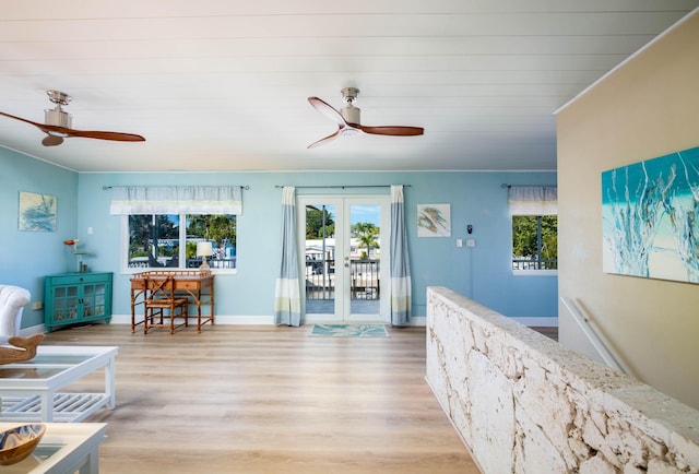 living room featuring ceiling fan, ornamental molding, light wood-type flooring, and french doors