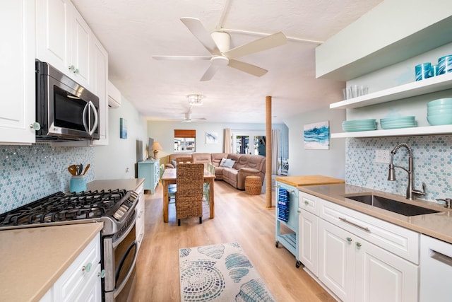 kitchen with stainless steel appliances, sink, and white cabinets