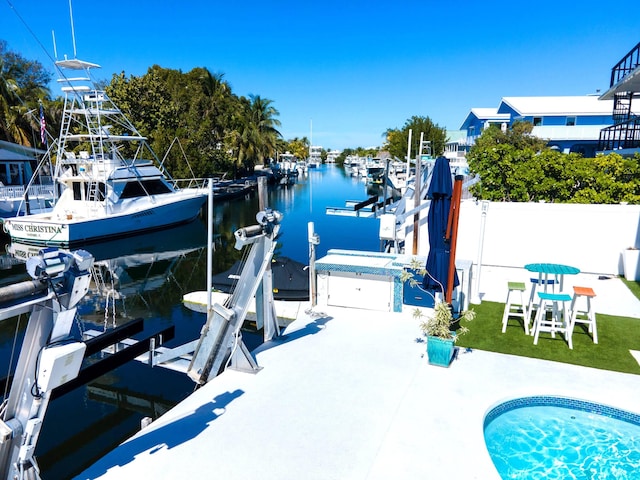 view of dock with a water view and a patio