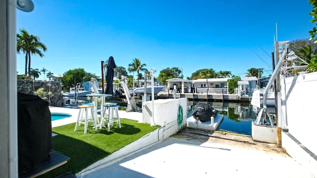 view of dock featuring a water view and a yard