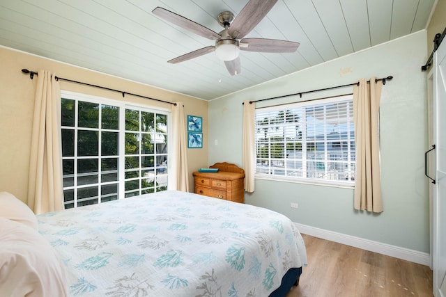 bedroom with ceiling fan, light wood-type flooring, multiple windows, and wooden ceiling