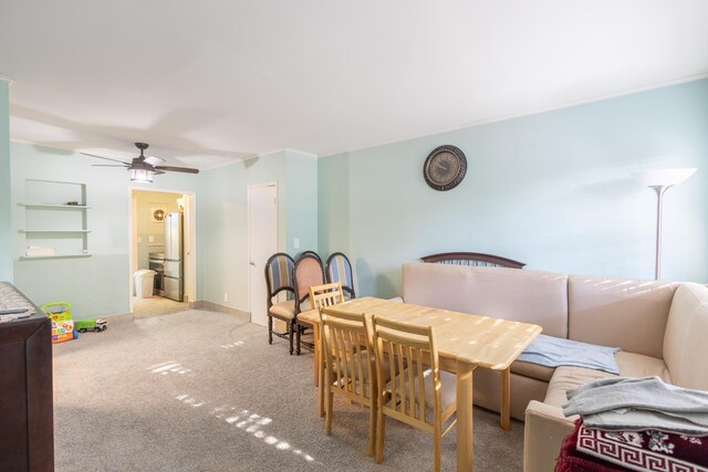 carpeted dining space with ceiling fan