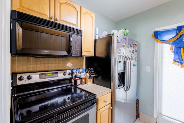 kitchen featuring appliances with stainless steel finishes, tile countertops, backsplash, and light brown cabinetry