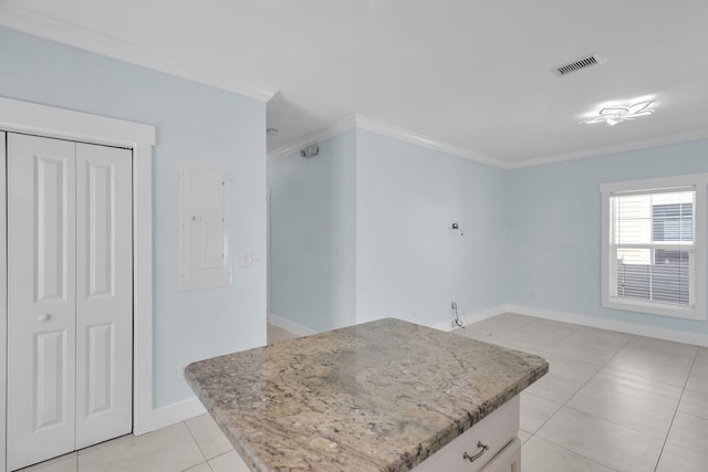 kitchen featuring light tile patterned floors, crown molding, a center island, and white cabinets