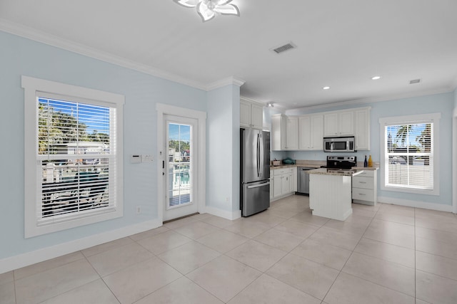 kitchen featuring white cabinetry, plenty of natural light, stainless steel appliances, a center island, and ornamental molding