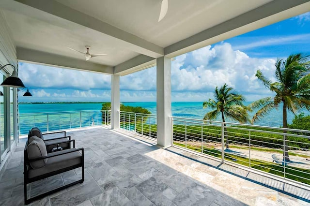 view of patio featuring ceiling fan, a balcony, and a water view