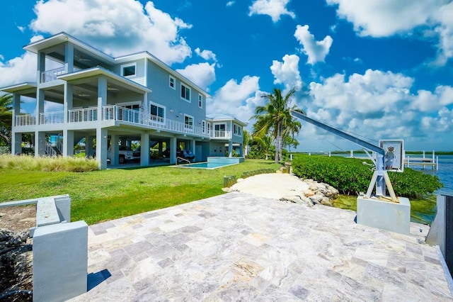 rear view of property with a balcony and a lawn