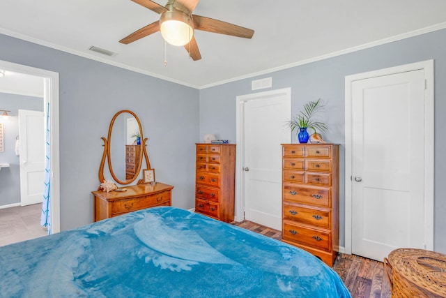 bedroom with hardwood / wood-style floors, crown molding, ceiling fan, and ensuite bathroom