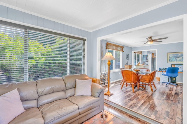 living room with hardwood / wood-style floors, crown molding, and ceiling fan