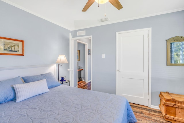 bedroom featuring ceiling fan, ornamental molding, and wood-type flooring