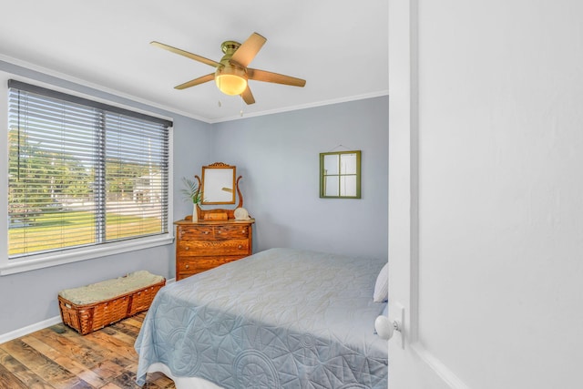 bedroom featuring ornamental molding, wood-type flooring, and ceiling fan