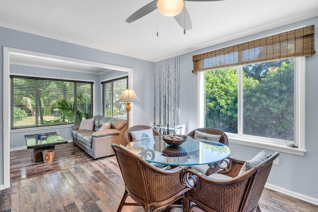 dining space featuring wood-type flooring, ornamental molding, and ceiling fan