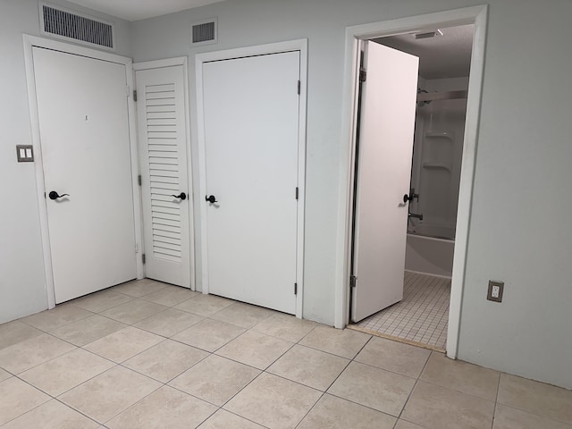 unfurnished bedroom with light tile patterned flooring and a closet