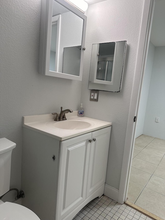 bathroom featuring vanity, tile patterned floors, and toilet