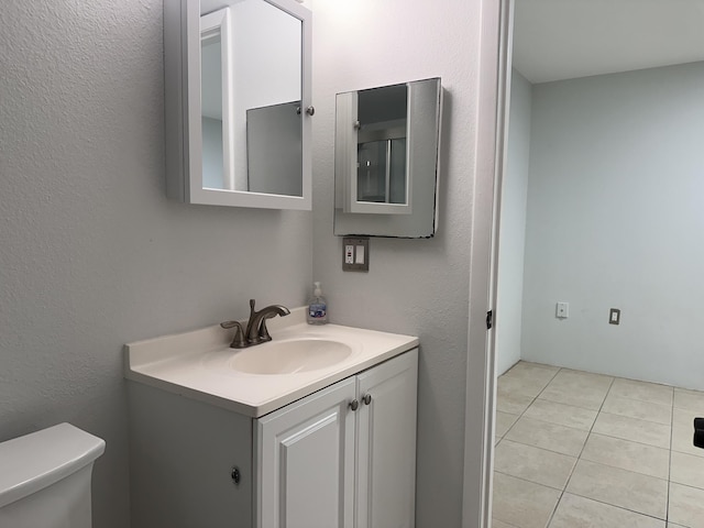 bathroom featuring tile patterned floors, vanity, and toilet