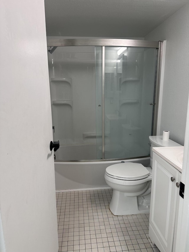 full bathroom with tile patterned floors, toilet, bath / shower combo with glass door, a textured ceiling, and vanity