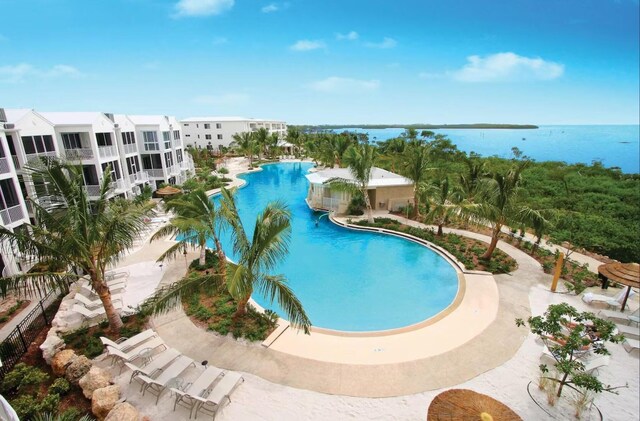 view of swimming pool with a patio area and a water view