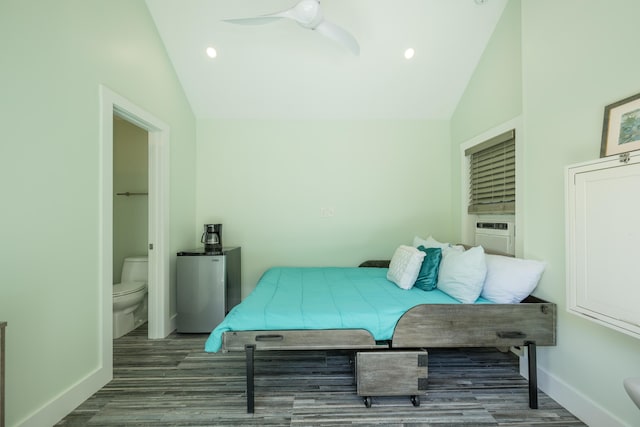 bedroom featuring fridge, ensuite bathroom, vaulted ceiling, and hardwood / wood-style floors