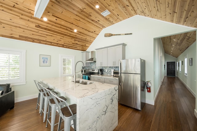 kitchen with white cabinetry, an island with sink, appliances with stainless steel finishes, and light stone counters