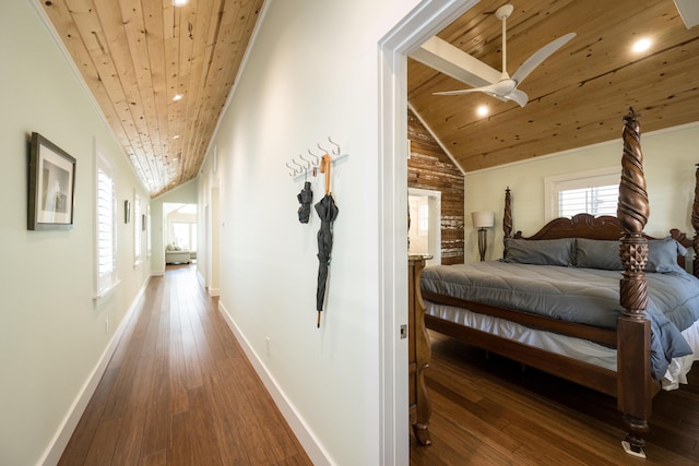 corridor with lofted ceiling, hardwood / wood-style floors, and wood ceiling