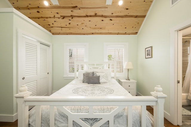 bedroom with crown molding, vaulted ceiling, wooden ceiling, and a closet