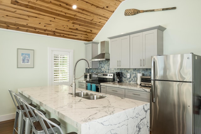 kitchen with appliances with stainless steel finishes, tasteful backsplash, an island with sink, wall chimney range hood, and wooden ceiling