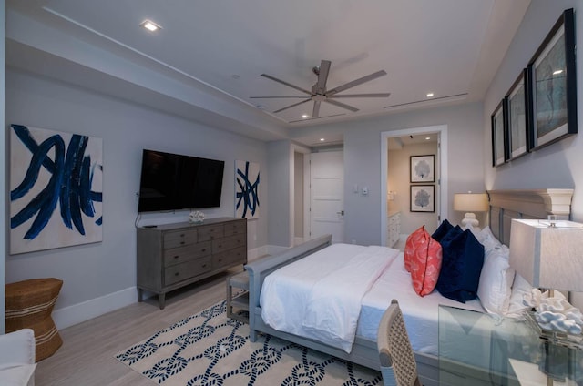 bedroom featuring ensuite bath, light hardwood / wood-style flooring, and ceiling fan