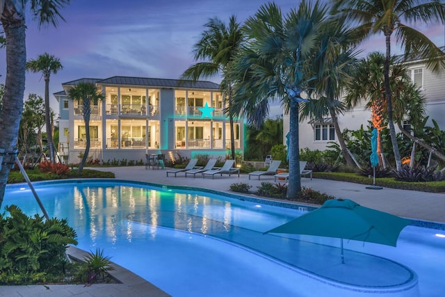 pool at dusk featuring a patio area