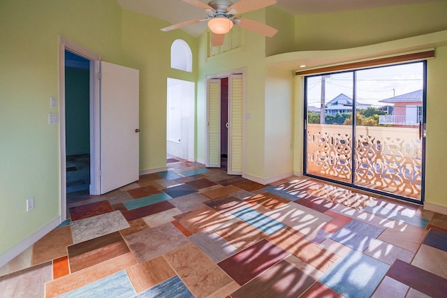 empty room with a towering ceiling and ceiling fan