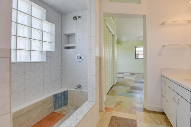 bathroom with vanity, plenty of natural light, and tiled shower