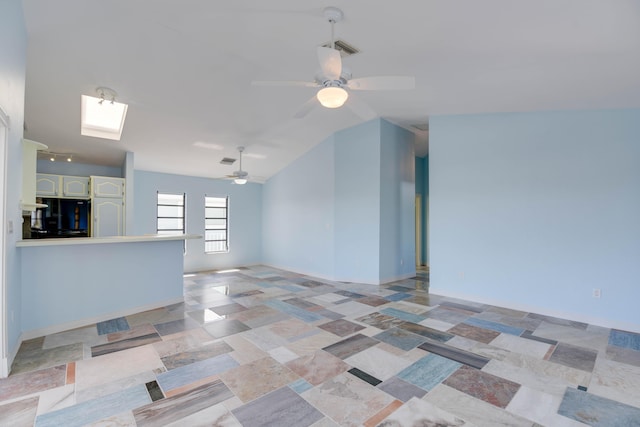 unfurnished living room featuring lofted ceiling with skylight and ceiling fan