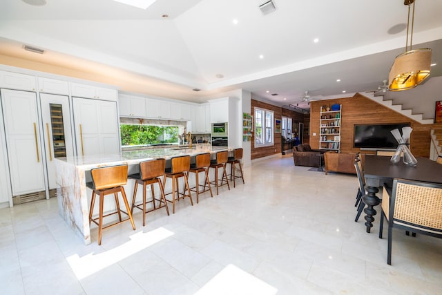 316 Southard St, Key West, FL 33040 - kitchen with white cabinetry, a kitchen bar, decorative light fixtures, lofted ceiling, and open floor plan