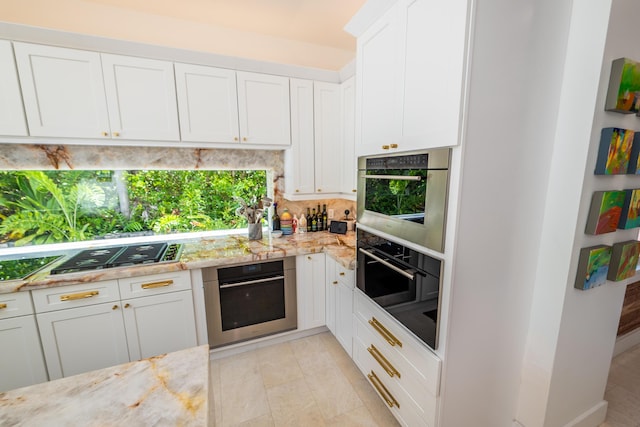 316 Southard St, Key West, FL 33040 - kitchen featuring stainless steel appliances, decorative backsplash, white cabinetry, light stone counters, and light tile patterned floors