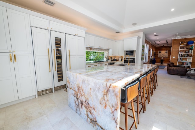 316 Southard St, Key West, FL 33040 - kitchen featuring a sink, white cabinets, light stone counters, a breakfast bar, and recessed lighting