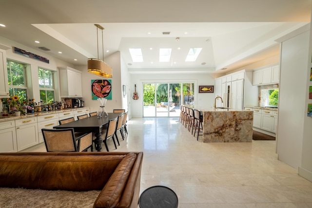 316 Southard St, Key West, FL 33040 - kitchen with a skylight, a raised ceiling, recessed lighting, light stone counters, and an island with sink