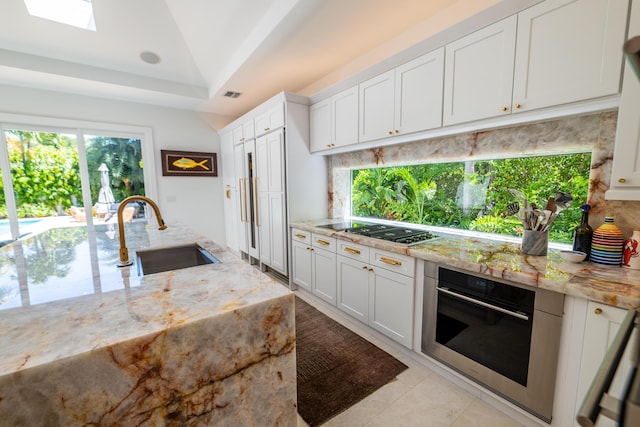 316 Southard St, Key West, FL 33040 - kitchen with stainless steel appliances, a sink, tasteful backsplash, and white cabinetry