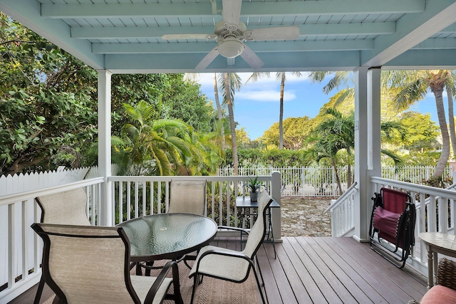 sunroom with beamed ceiling and ceiling fan