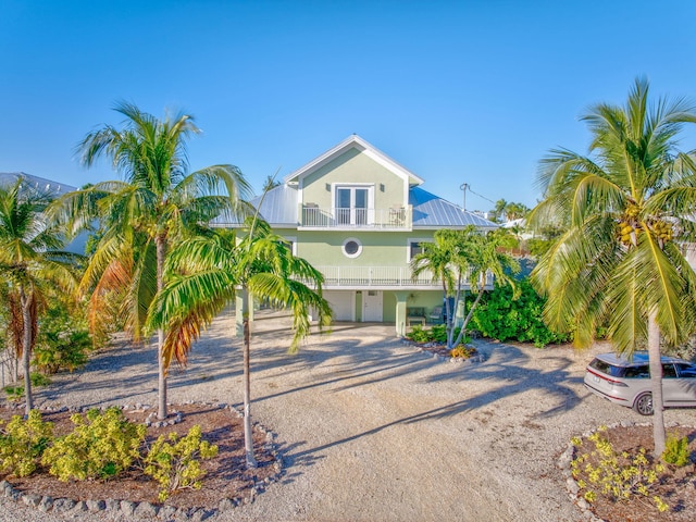 raised beach house with a carport, a balcony, and french doors