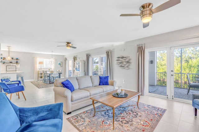 living room with french doors, ceiling fan, and light tile patterned floors