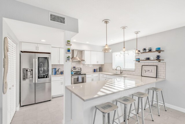 kitchen featuring appliances with stainless steel finishes, a breakfast bar, sink, and white cabinets