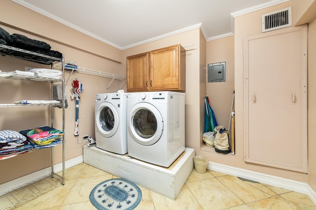 clothes washing area featuring light tile patterned floors, crown molding, washer and clothes dryer, and cabinets