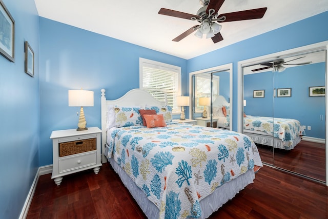 bedroom featuring two closets, dark wood-type flooring, and ceiling fan