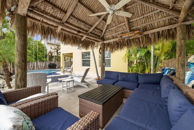 view of patio featuring a gazebo, ceiling fan, outdoor lounge area, and a fenced in pool