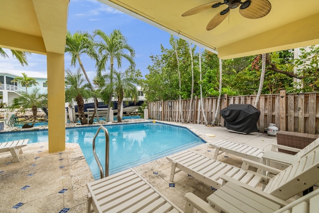 view of swimming pool featuring a grill, a patio, and ceiling fan